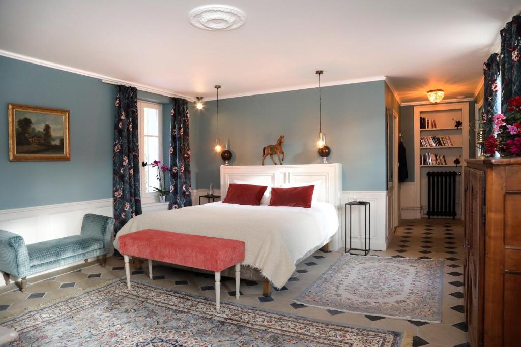 Le Plessis-LuzarchesDomaine du Plessis的卧室配有白色的床和红色椅子