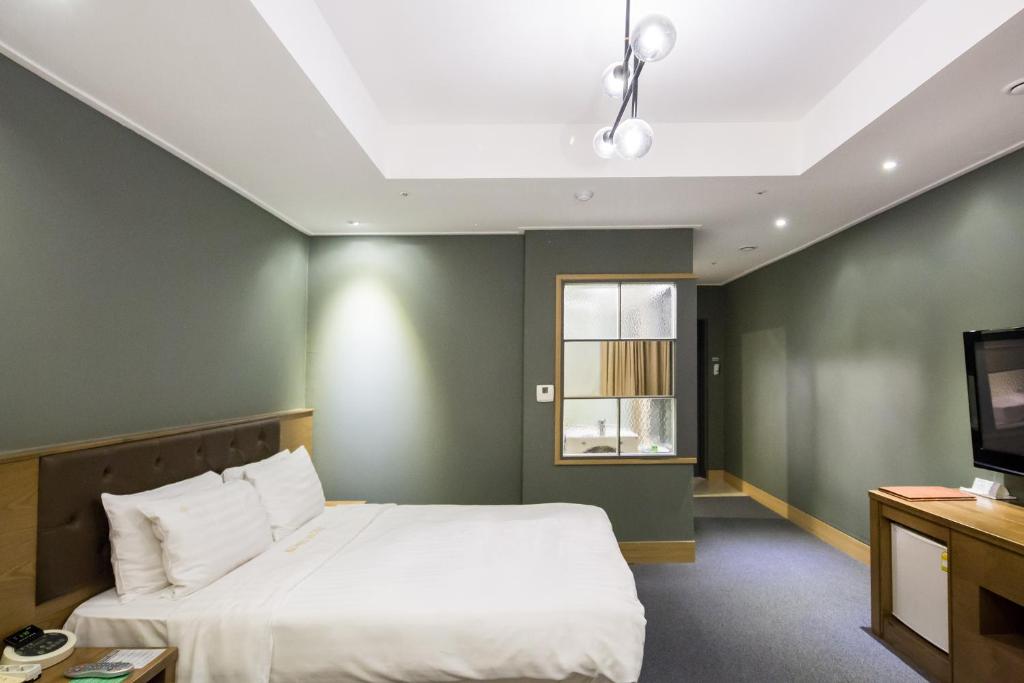 富川市高丽酒店的一间卧室配有一张大床和电视