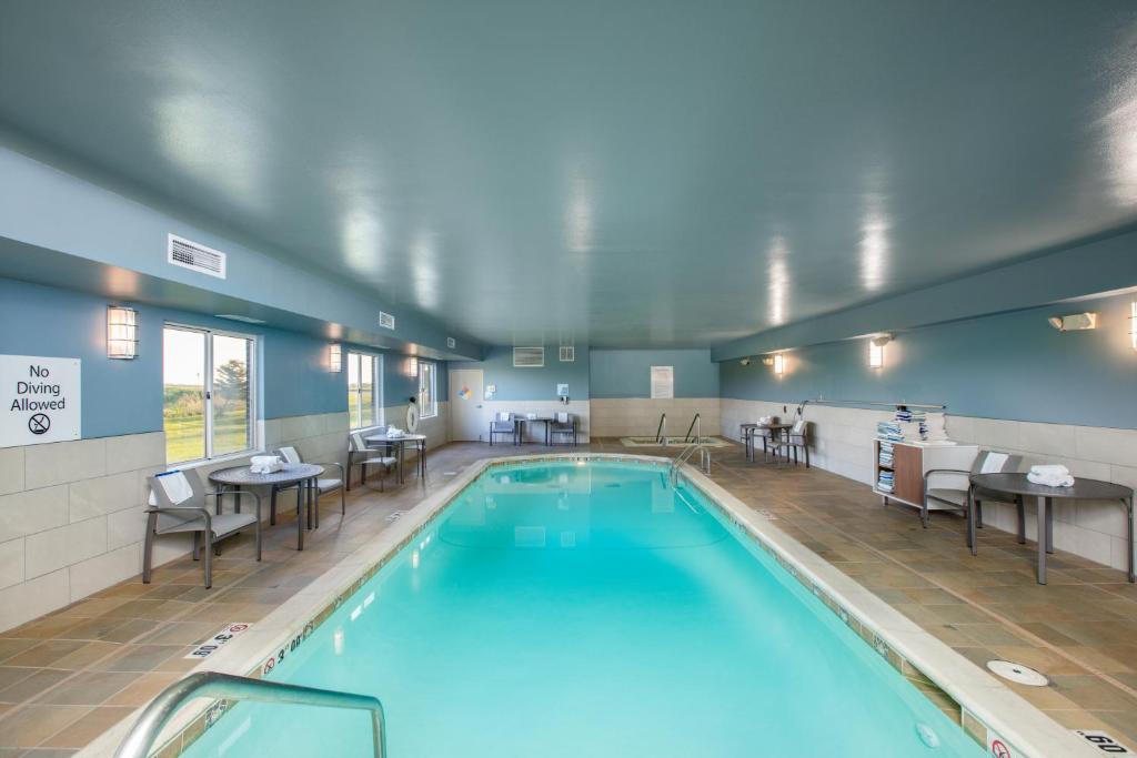 阿尔图纳阿尔图纳智选假日套房酒店 - 德梅因的大楼内带桌椅的游泳池