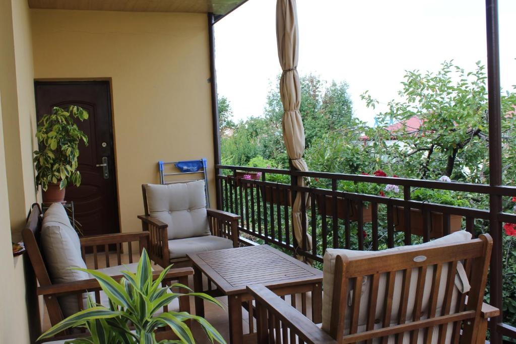 泰拉维Tinikos Guest House的阳台配有椅子、桌子和窗户。