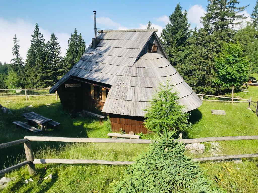 卡姆尼克Chalet Gasparjeva Velika Planina的田野中带锡屋顶的谷仓