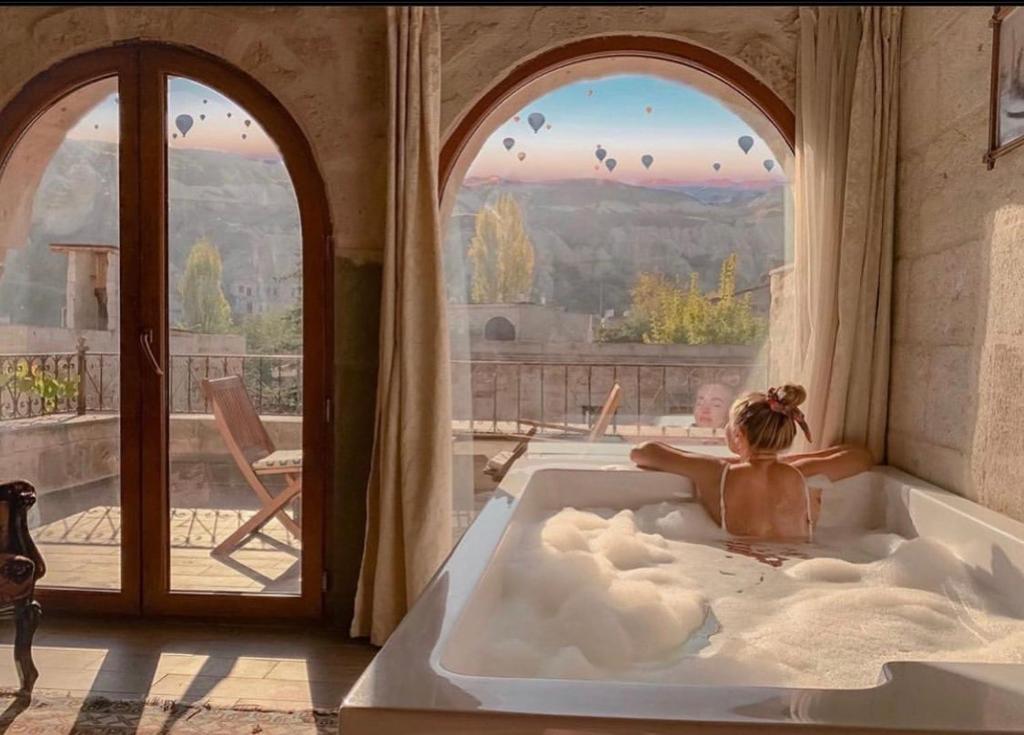 格雷梅天使洞穴套房酒店的儿童在带窗户的客房内的浴缸里