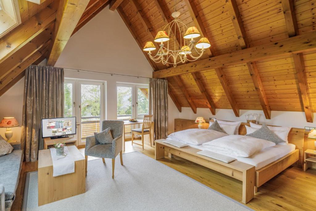 科齐扎尔滕施莱格霍夫旅馆的一间带一张大床的卧室,位于一个拥有木制天花板的房间
