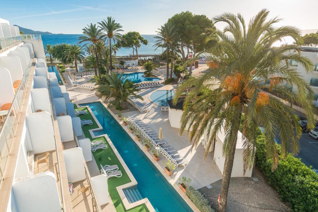 穆罗海滩Aparthotel Ses Fotges的享有度假村的空中景致,设有游泳池和棕榈树