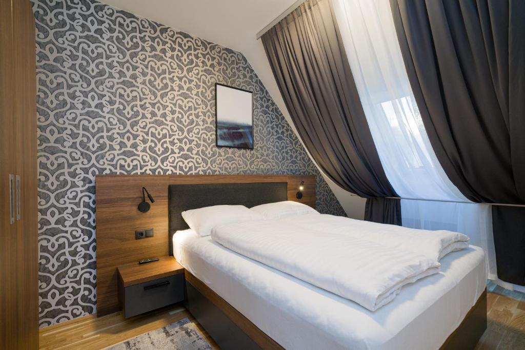 维也纳MyApartments Vienna的一间卧室设有一张床和一面墙