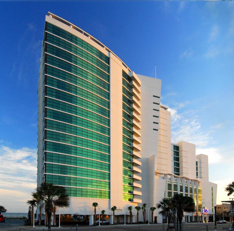 默特尔比奇沙滩度假酒店的一座高大的建筑,前面有棕榈树