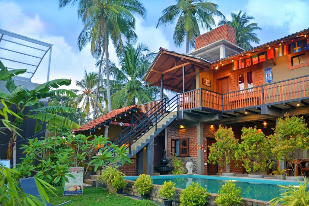 尼甘布Negombo The Nature Villa and Cabanas的一座房子,设有楼梯,毗邻游泳池