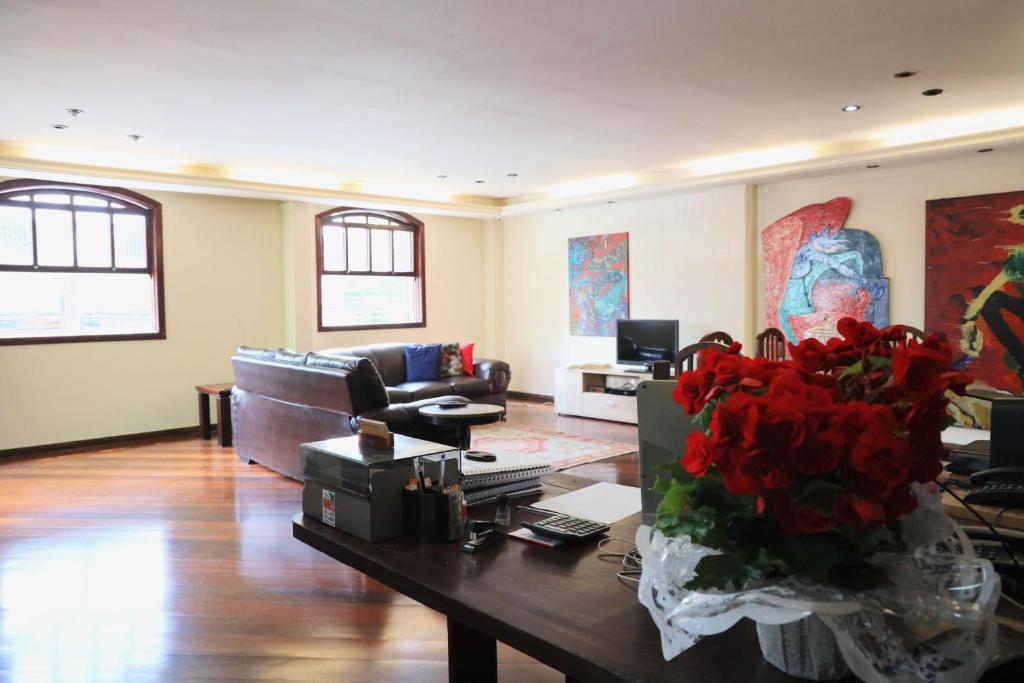 尼泰罗伊阿内霍望厦宾馆 的客厅配有沙发和红色鲜花桌