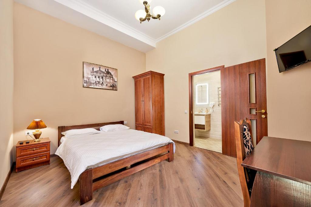 利沃夫哥萨克旅馆 的一间卧室配有一张床、一张桌子和一张书桌