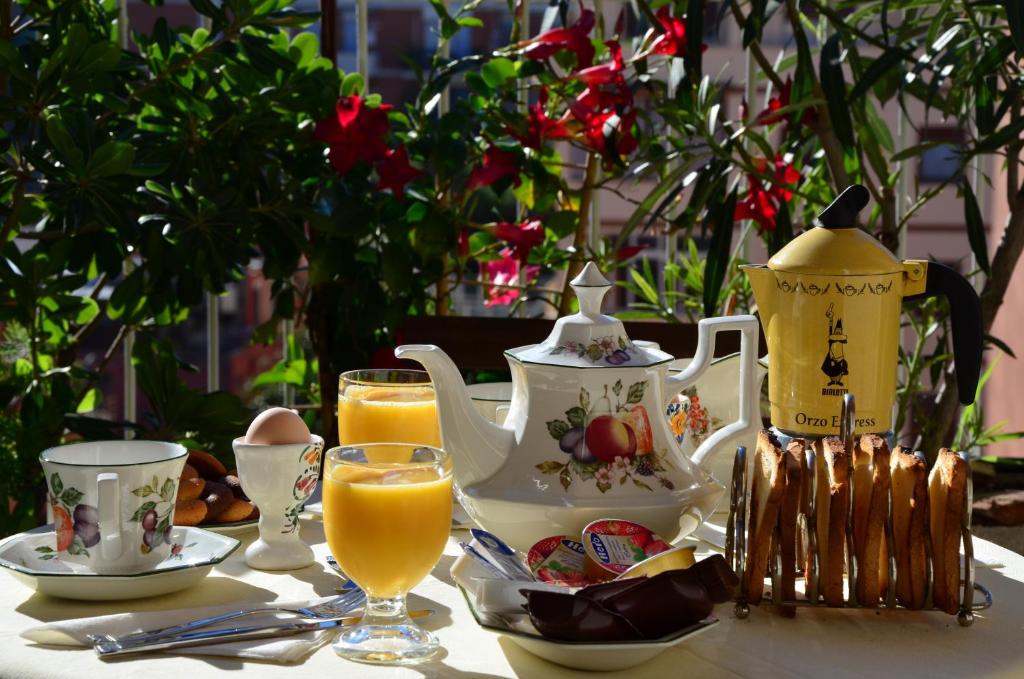 罗马B&B SPLENDIDAE MUNDI的茶壶、杯子和橙汁的桌子
