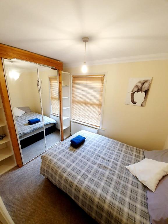 切姆Chelmsford Centre House的一间小卧室,配有一张床和镜子