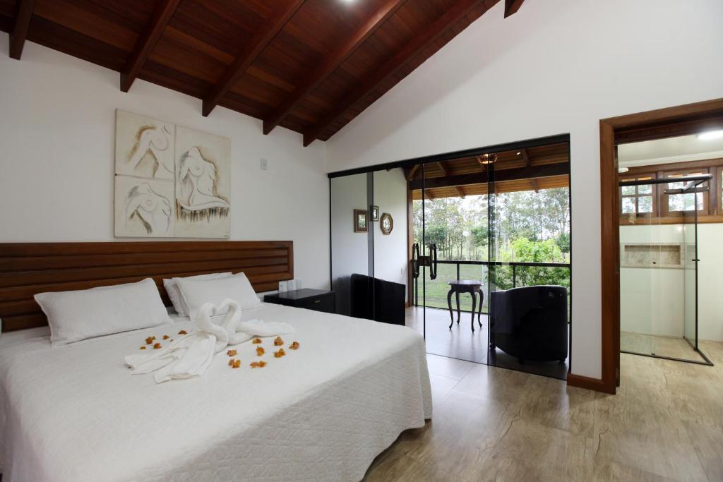 戈亚斯州上帕莱索Estancia Jacy的卧室配有一张白色大床和玻璃门