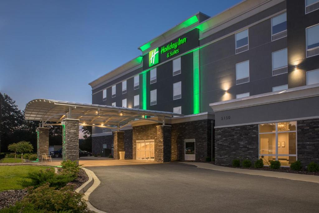 迪凯特Holiday Inn & Suites Decatur-Forsyth, an IHG Hotel的前面有一个绿色标志的酒店
