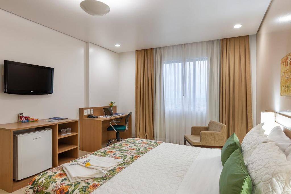 马瑙斯蓝树普利姆酒店的酒店客房配有一张床、一张书桌和一台电视。