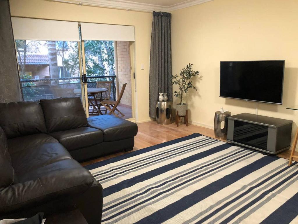 悉尼Escape to Strathfield for 8 guests的带沙发和平面电视的客厅