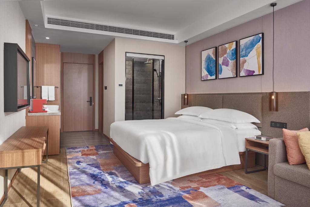 金边Aurea Central Hotel的卧室配有一张白色的大床和一张沙发。