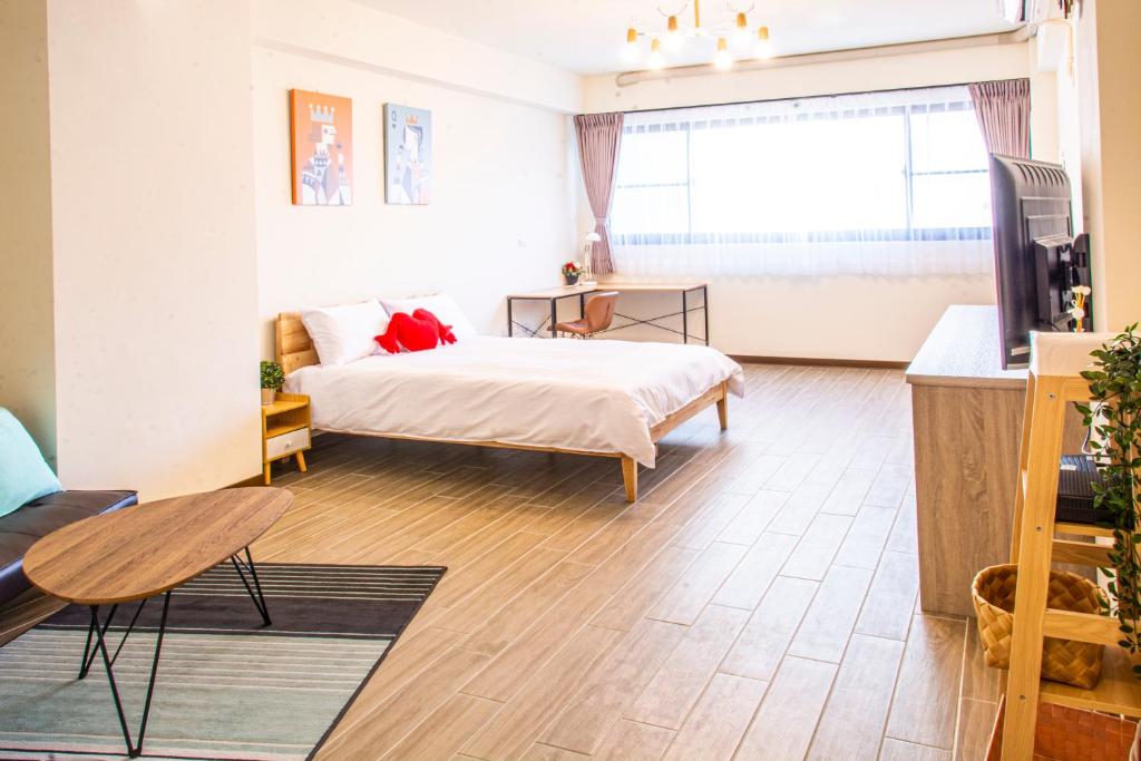 台南ioio的一间卧室配有一张床、一张桌子和一台电视。