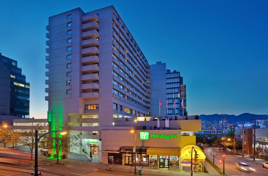 温哥华温哥华中心百老汇假日酒店的夜幕降临的城市街道上一座高楼