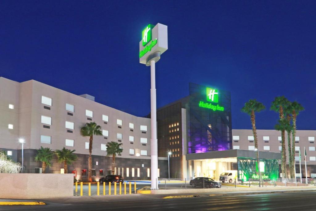 华雷斯城Holiday Inn - Ciudad Juarez, an IHG Hotel的一座建筑,上面有绿色标志