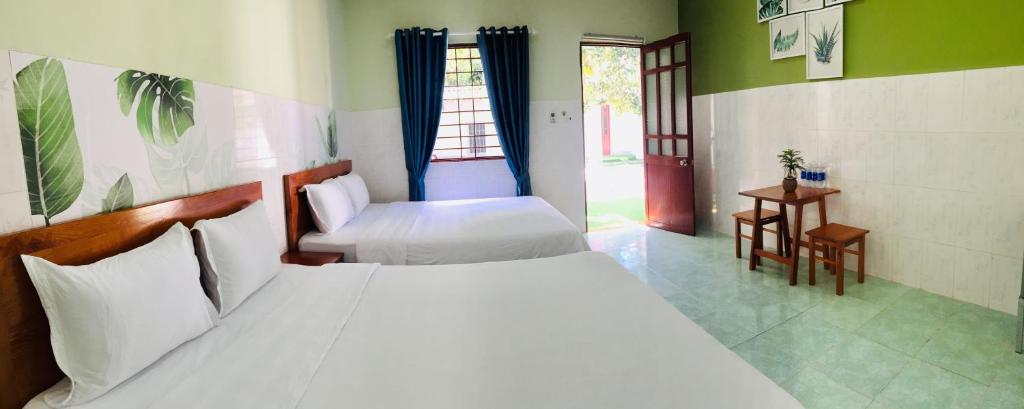 昆岛Eden House & Coffee Con Dao的一间卧室设有两张床和窗户。