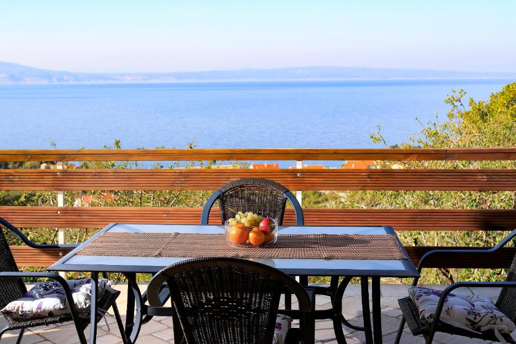 克罗诺维察Apartment Vincent with beautiful sea view terrace的阳台上的桌子上放着一碗水果