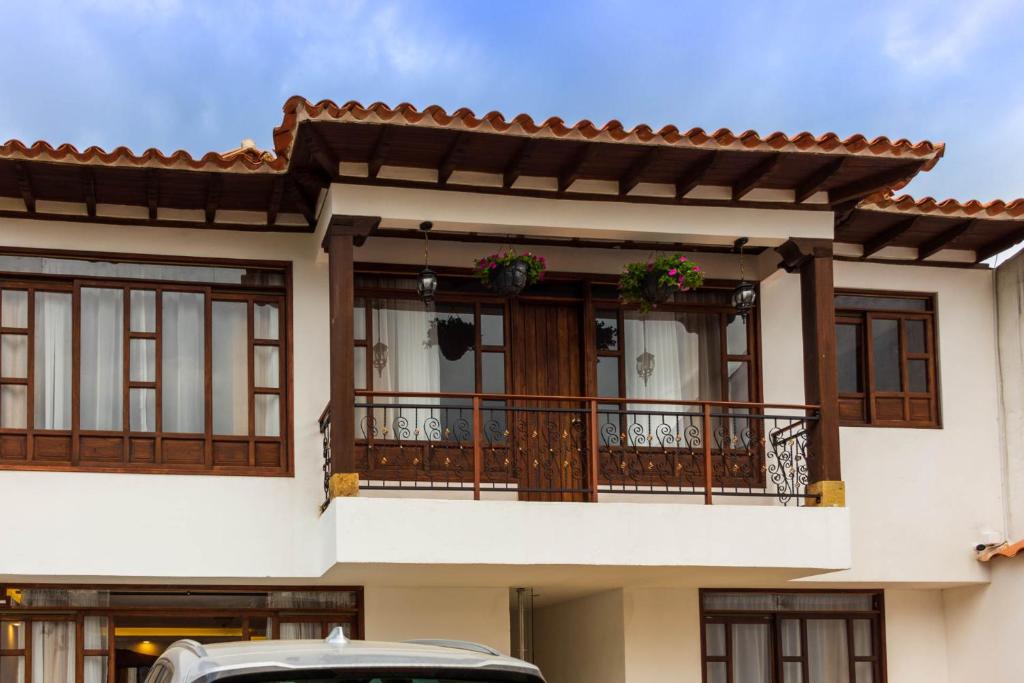 莱瓦镇HOTEL ENCANTO COLONIAL的带阳台的房子和前方的停车位