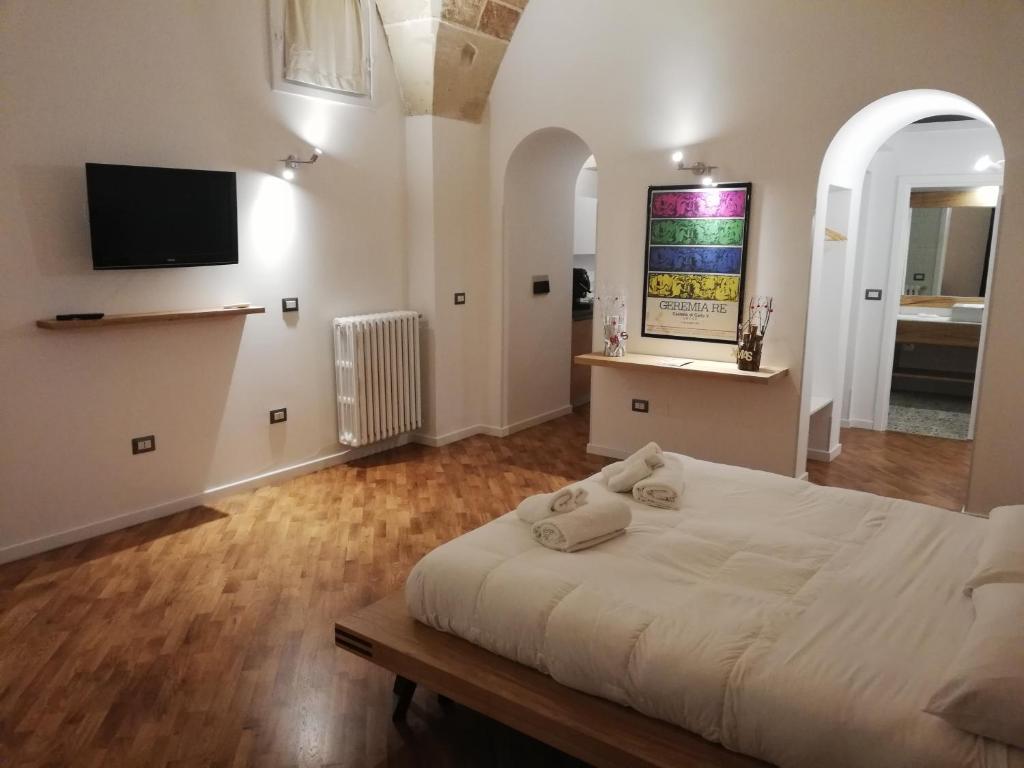 莱切铁托斯奇帕住宿加早餐酒店的卧室配有白色的床和墙上的电视。