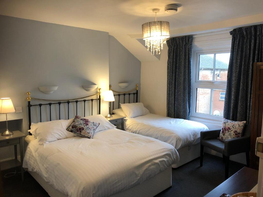 牛津Newton House Oxford的酒店客房设有两张床和窗户。