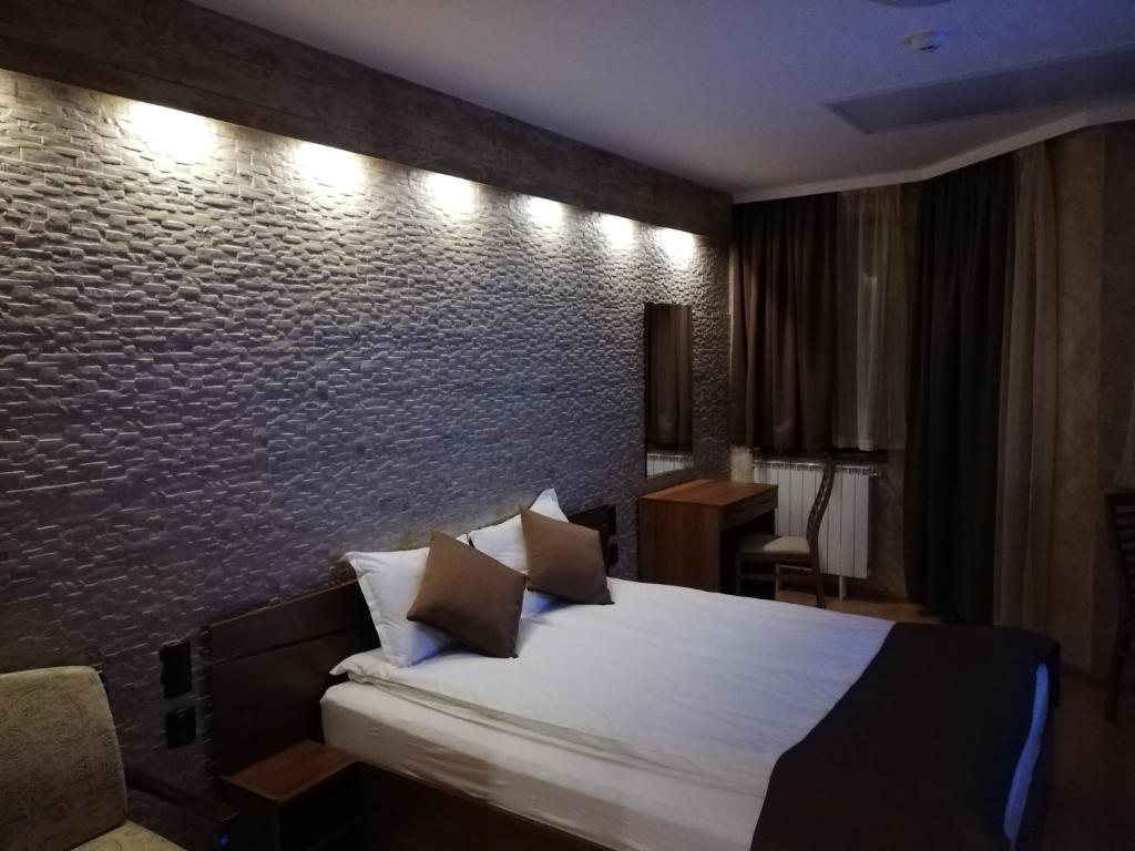 波罗维茨HQ apartments Villa Park的一间卧室设有一张床和砖墙