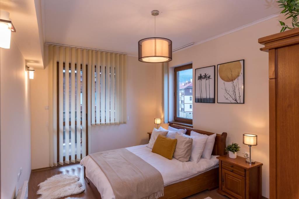 班斯科Charming Ski Apartments Near Gondola & Bar Street, Cedar Lodge 1 Complex的一间卧室配有一张带白色床单的床和一扇窗户。