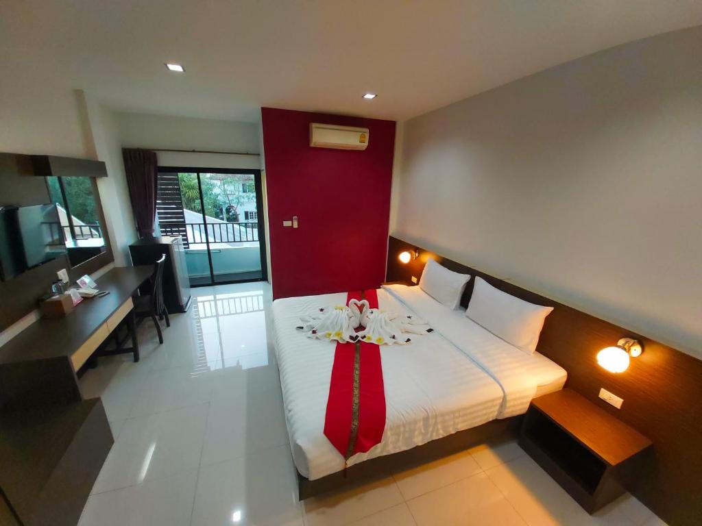 乌隆他尼赛瑞普利斯酒店的一间卧室配有一张大床和红色床头板
