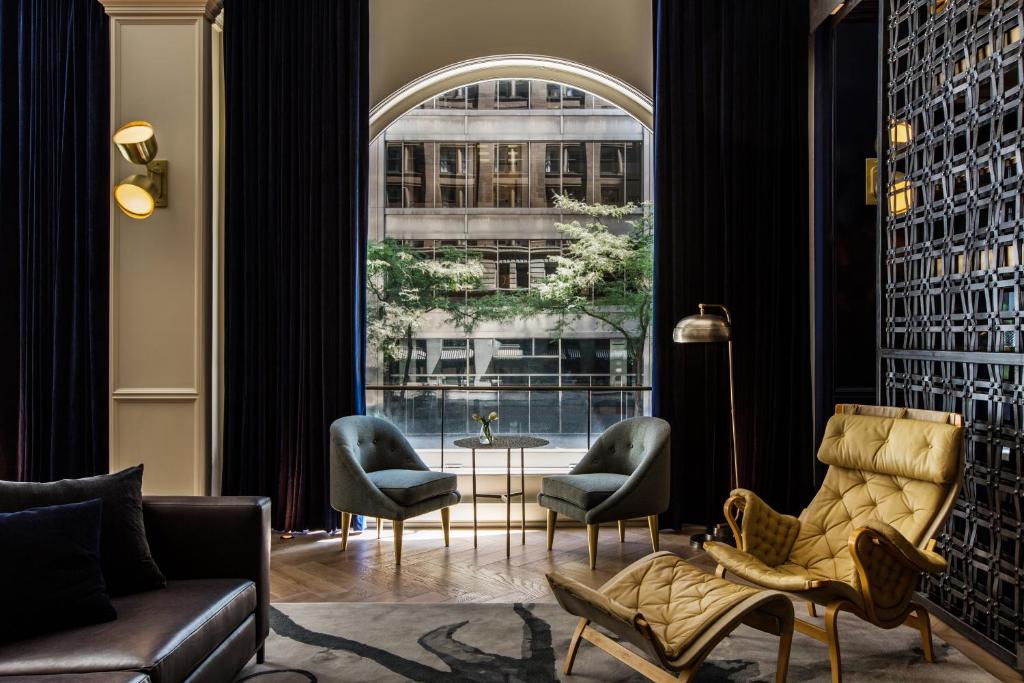 芝加哥Kimpton Gray Hotel Chicago, an IHG Hotel的客厅配有椅子和大窗户