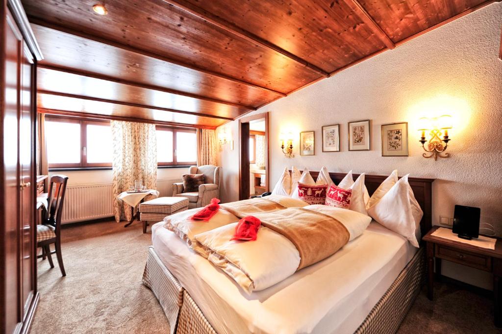 莱赫阿尔贝格哈登霍夫酒店的一间卧室配有一张大床,上面有红色的弓