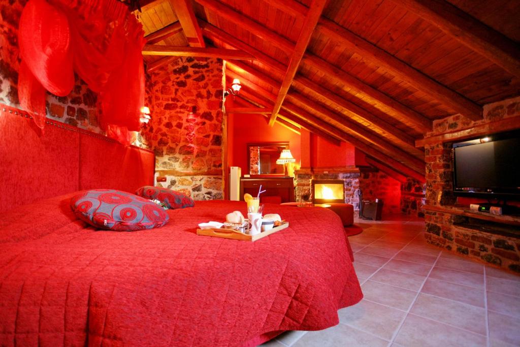 帕雷斯阿吉萨那Patriko Mountain Chalet的一间卧室配有红色的床和电视