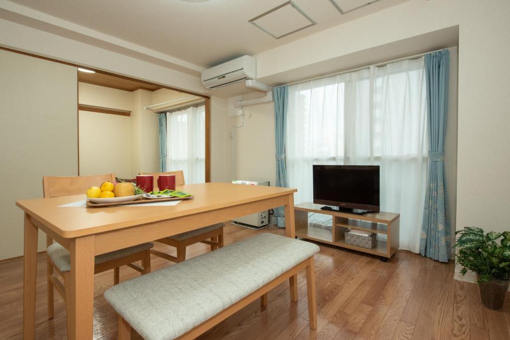 札幌札幌市中心部大通公園まで徒歩十分観光移動に便利なロケーションh602的客厅配有桌子和电视