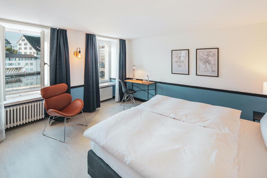 苏黎世Pop Up Hotel Krone Zürich的一间卧室配有一张床、一张书桌和一个窗户。
