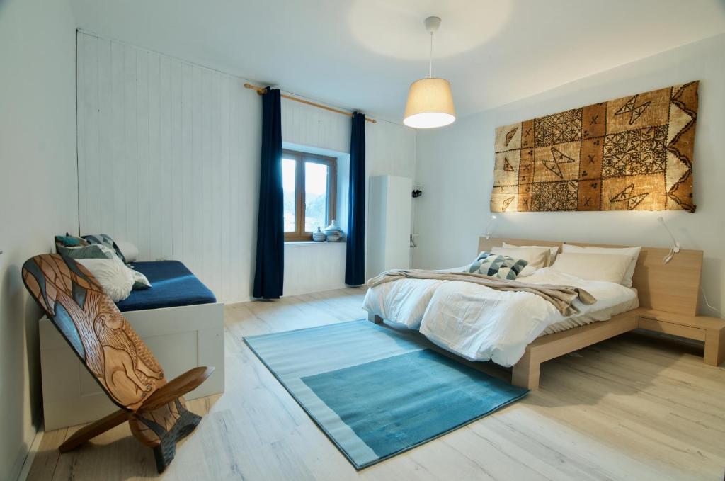 佩尔吉内瓦尔苏加纳Al Maset di TSS' - Green Apartament - Zona Living Spaziosa - Perfetto per Famiglie Numerose a Pergine Valsugana的一间卧室配有一张床和蓝色地毯