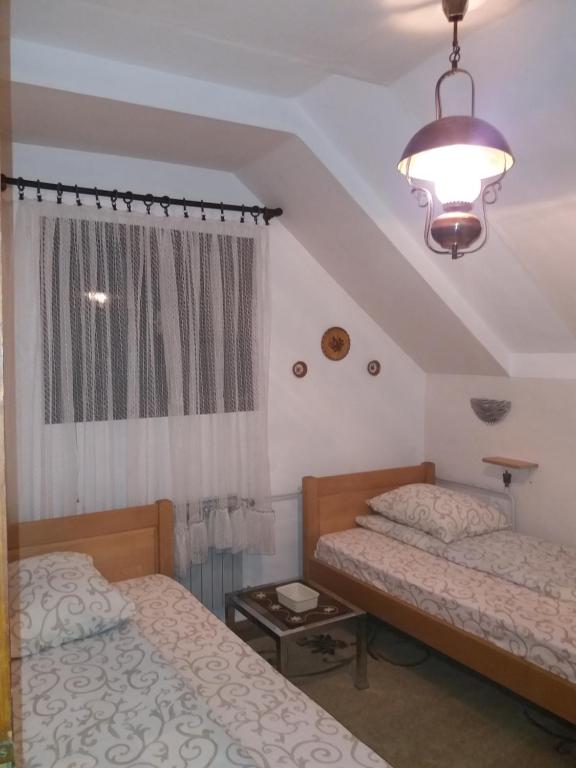 扎布利亚克Apartments Beka的一间卧室设有两张床、一盏灯和一扇窗户。