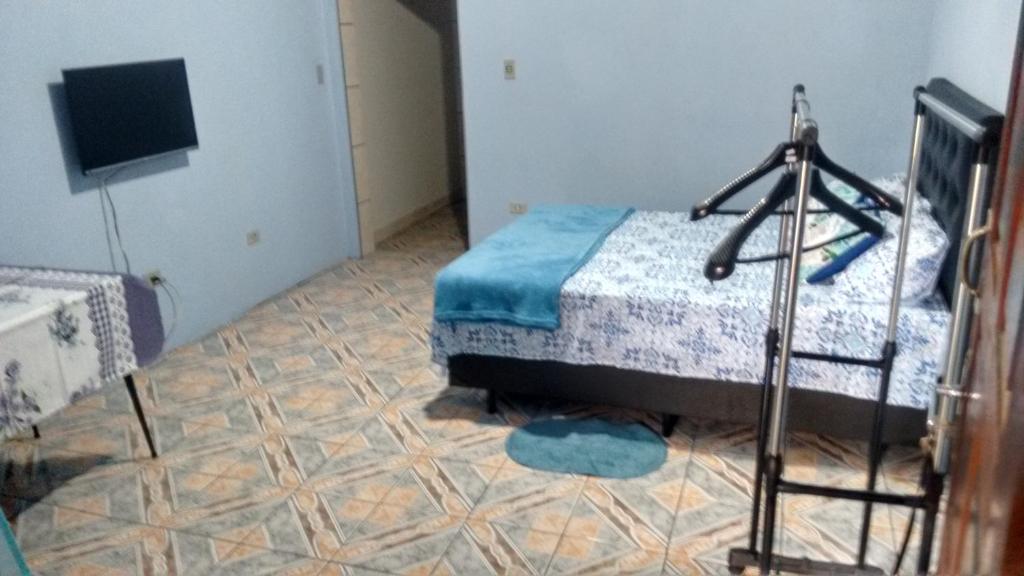 瓜鲁柳斯Quarto familiar, aeroporto Guarulhos的一间设有床铺和电视的房间
