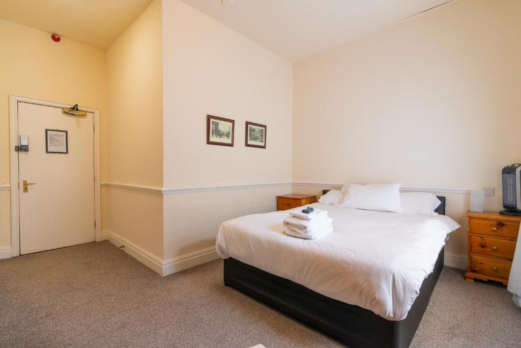 曼彻斯特Old Trafford Stadium Hotel的一间卧室配有白色床单
