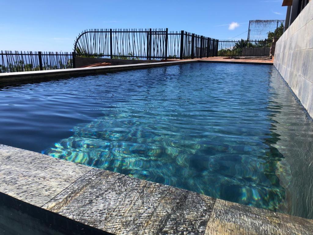 圣勒OCEAN SUNSET的蓝色海水游泳池和围栏