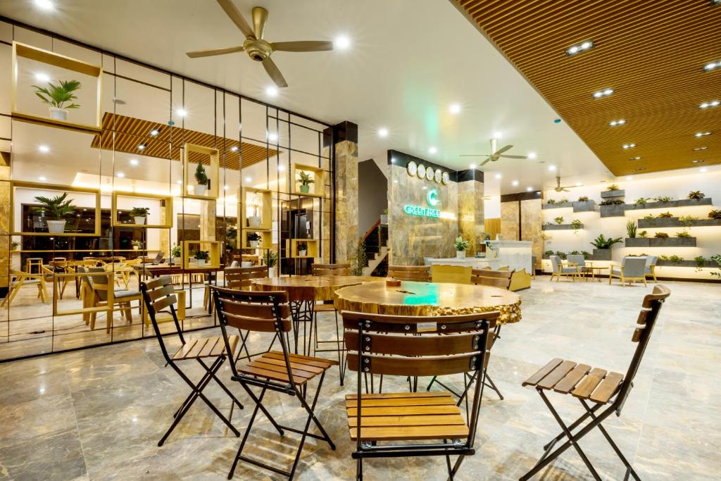 富国Green Tree Hotel Phú Quốc的商店里带桌椅的餐厅