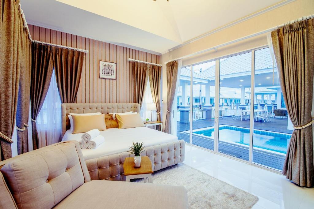 华欣华欣博安马文度假屋的一间带大床的卧室和一个游泳池