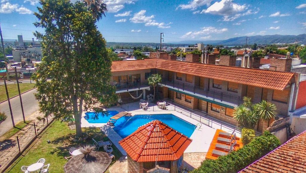 维拉卡洛斯帕兹Hotel Carlos Paz的享有带游泳池的房屋的空中景致