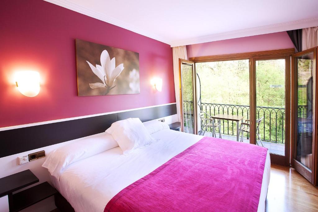 埃特克萨拉尔文塔德埃萨拉尔酒店的一间卧室配有一张带粉色毯子的大床