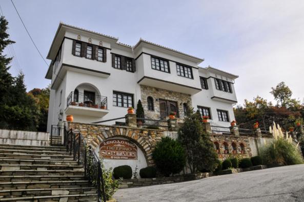 马克里尼撒佩特里诺酒店的一座白色的大房子,设有石墙