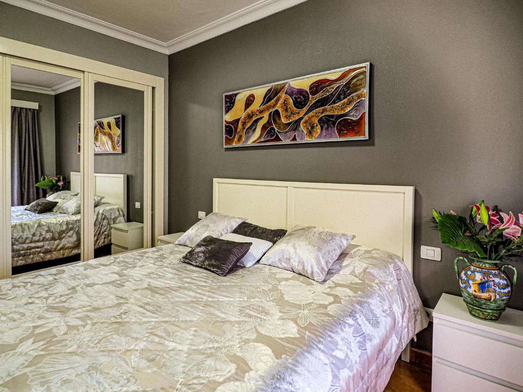 拉克鲁斯完美公寓的卧室配有一张床,墙上挂有绘画作品