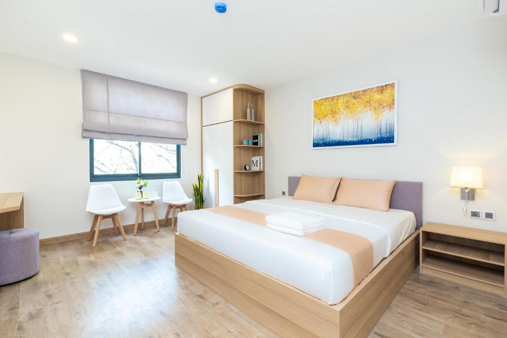 胡志明市Cozrum Lux Hotel的卧室配有一张白色大床和一张书桌