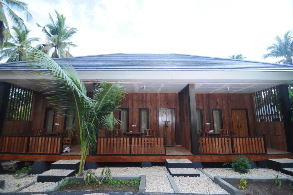 SelayarSunari Beach Resort 2的一座配有木镶板和棕榈树的房子