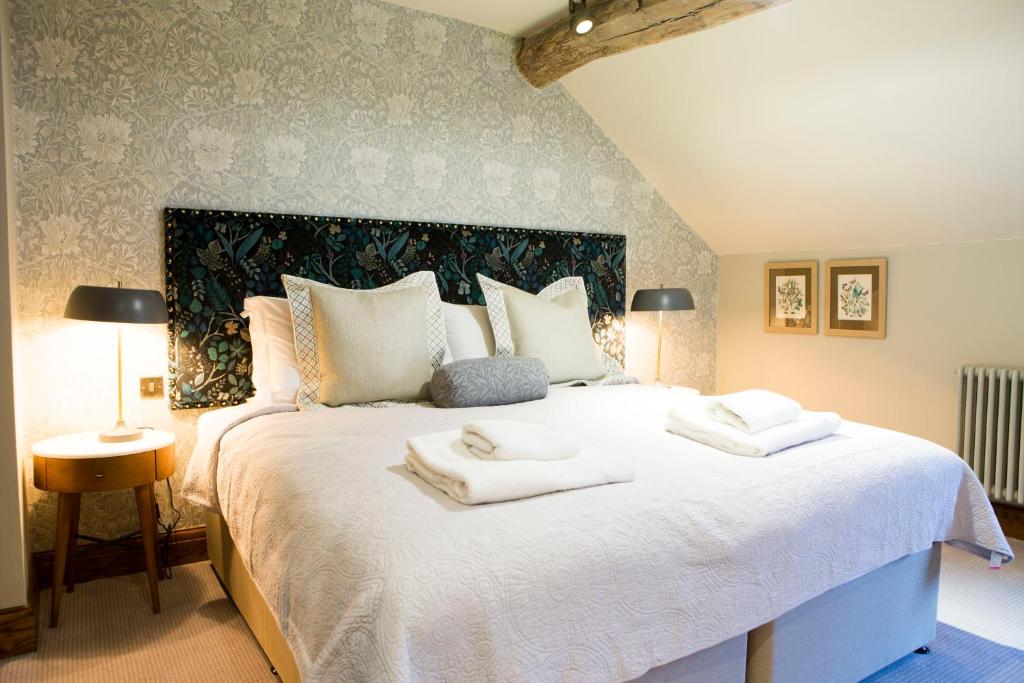 麦克尔斯菲尔德The Legh Arms Prestbury的卧室配有带毛巾的大型白色床